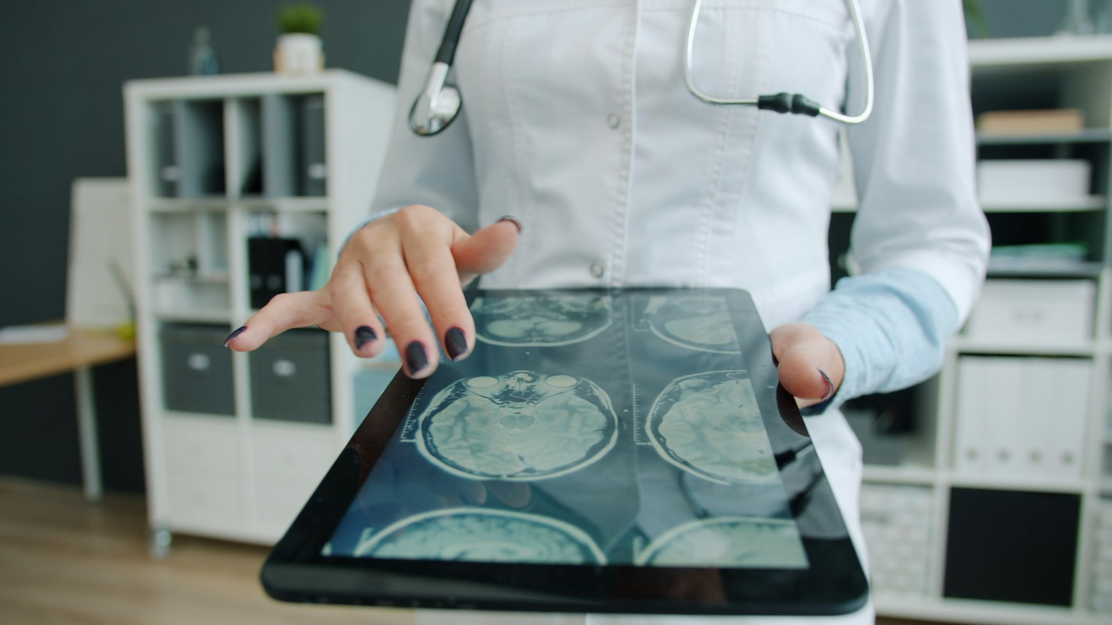 A clinician reviewing scan images on a tablet