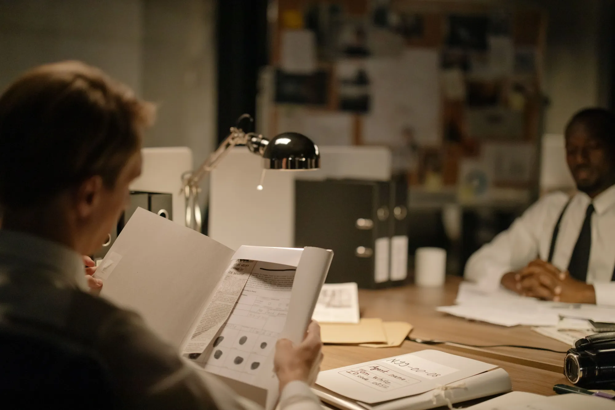 Two colleagues reviewing case documents and files together at a desk